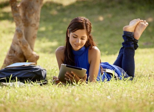 Woman with books and ipad studying for college test